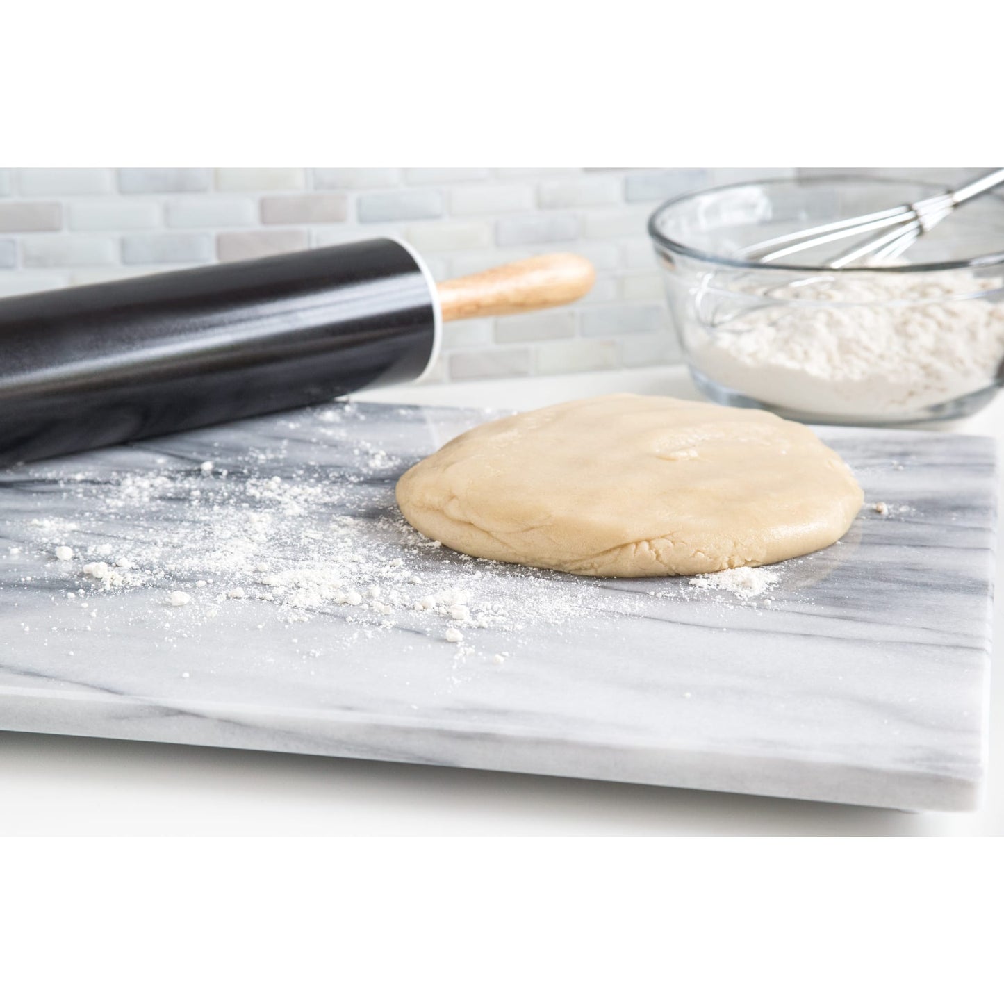 Silky smooth marble surface with dough ready for rolling, a wooden-handled rolling pin, and a glass bowl of flour with whisk, featured in Kitchen & Food and Baking Supplies collections.