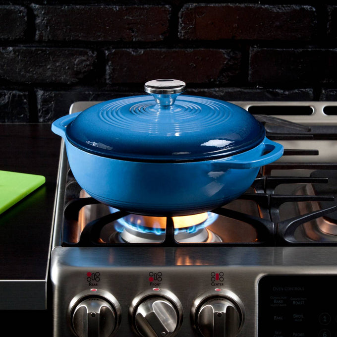 Handcrafted Lodge enameled cast iron 3-quart Dutch oven in vibrant blue with a shiny metal knob, sitting on a gas stove flame, featured in Kitchen & Food, Cookware, Cast Iron collections.