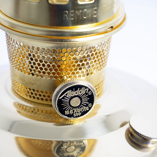 Close-up of a polished brass oil lamp burner with perforated ventilation, featuring an adjustable wick knob labeled for maximum brightness, part of a handcrafted lighting collection ideal for farm, garden, and emergency use.