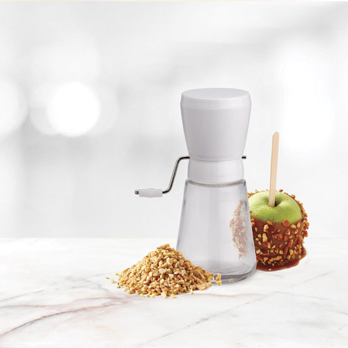 Compact nut chopper featuring stainless steel blades and a sturdy plastic hopper, shown with chopped nuts and a caramel-coated apple, ideal for Kitchen & Food and Food Prep collections.