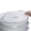 Flexible nonstick mesh screen being placed on stack of white dehydrator trays, designed to prevent small foods from falling through, ideal for food preservation and kitchen use