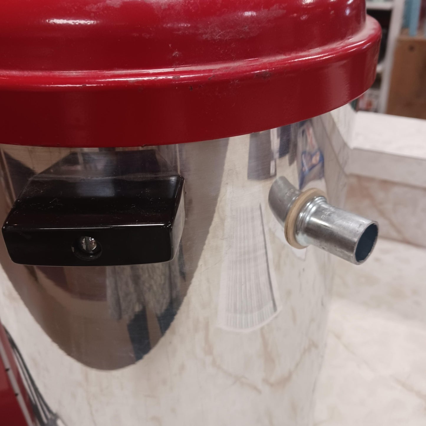 Close-up of a stainless steel milk pasteurizer with a red lid and side spout, designed for safe milk processing, featured in Farm, Garden & Tool and Animal Care collections.