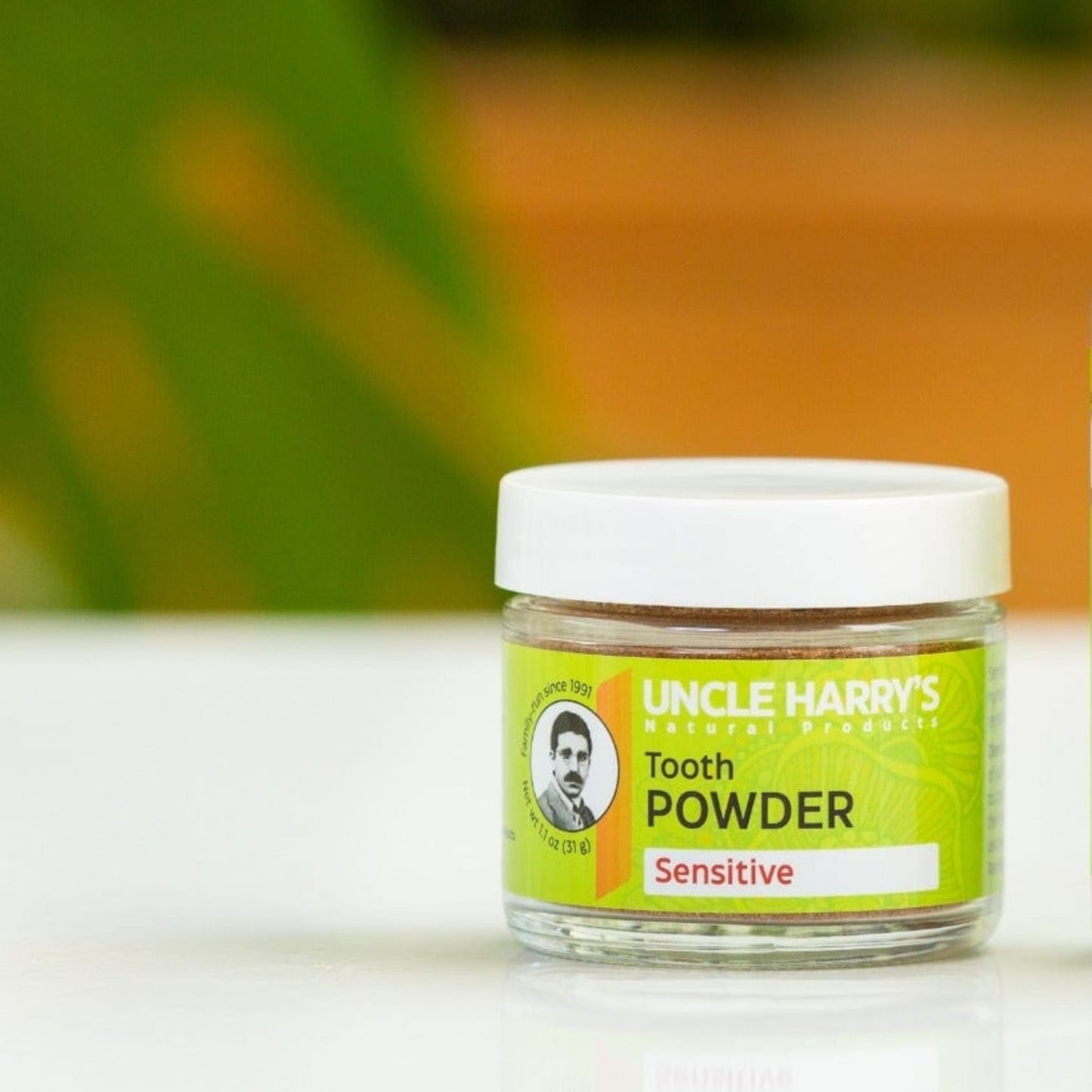 Small clear jar of handcrafted tooth powder for sensitive teeth with bright green label and white lid, promoting gentle oral care in Health & Wellness and USA Made collections.