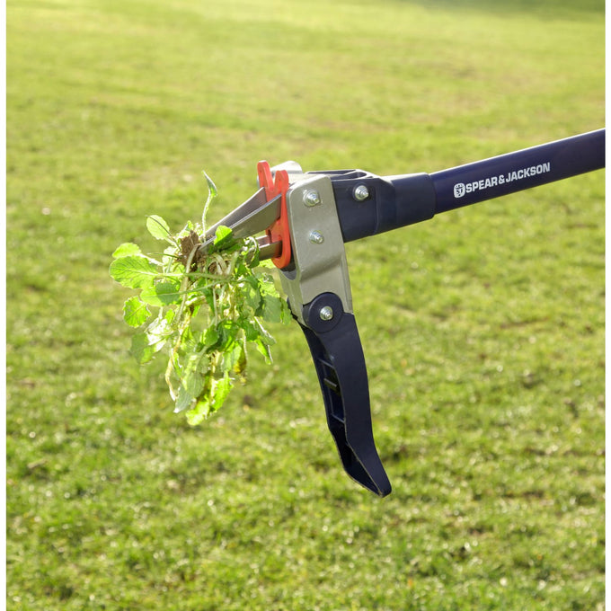 Mechanical weed puller with rust-resistant stainless steel claws and long nylon fiberglass handle removing a weed from a grassy lawn, featured in Farm, Garden & Tool, Garden Accessories, Lawncare, and Best Sellers collections.