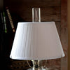 White cloth pleated oil lamp shade softening light from an Aladdin lamp, crafted for durability and featured in Lamps & Lighting, Lamp Shades, and Parts and Accessories collections.