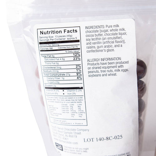 Back of a resealable bag showing nutrition facts, ingredient list, and allergy information for handcrafted milk chocolate covered raisins, made in USA, featured in Kitchen & Food, Snacks and Sweets, Candy, USA Made, Best Sellers, and Promo Eligible collections.