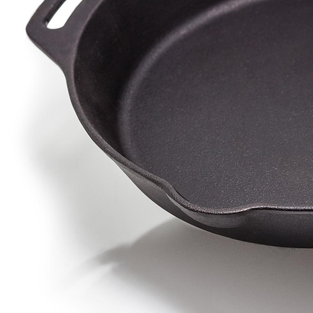 Close-up of a handcrafted cast iron skillet with two side handles and a pouring spout, ideal for use in farm, garden, kitchen, camping, cookware, and cast iron collections.