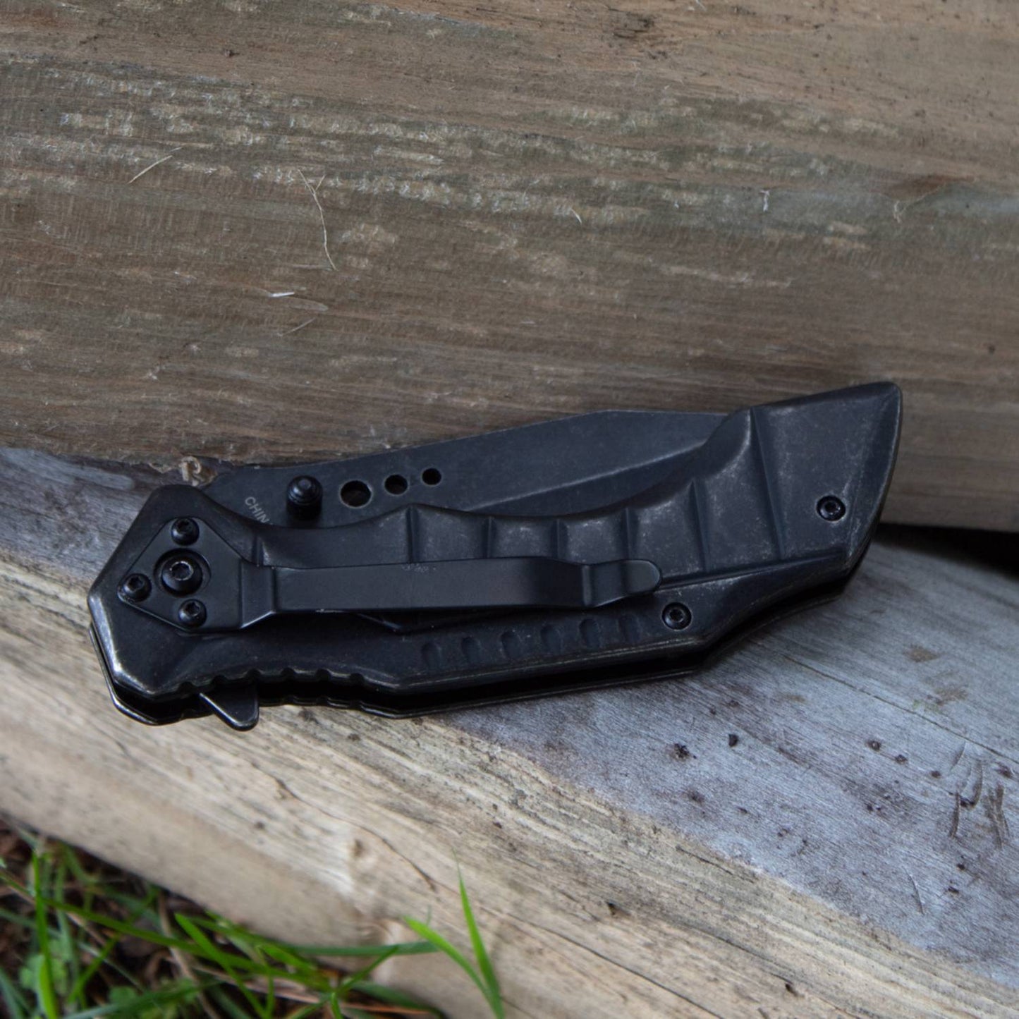 Blackened stainless steel Smithy's lockback folding knife with textured ergonomic handle and sturdy pocket clip, ideal for farm, garden, and tool use.