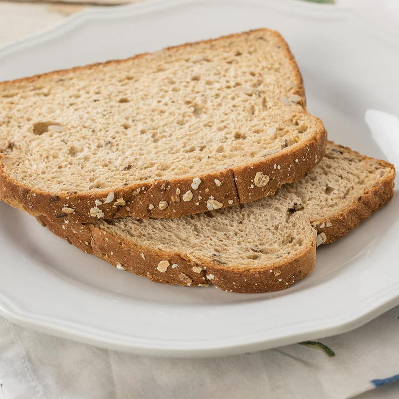 Two slices of wholesome 12-grain bread with oat flakes on the crust, displayed on a white plate, ideal for Kitchen & Food, Freeze Dried, USA Made, and Best Sellers collections.
