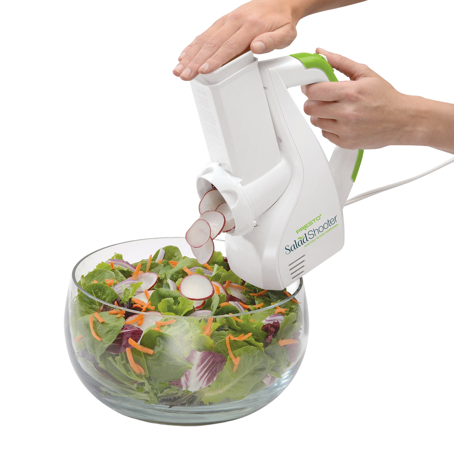 White and green electric vegetable slicer shredding radishes directly into a glass bowl of mixed fresh salad greens and shredded carrots, ideal for Kitchen & Food and Food Prep collections.