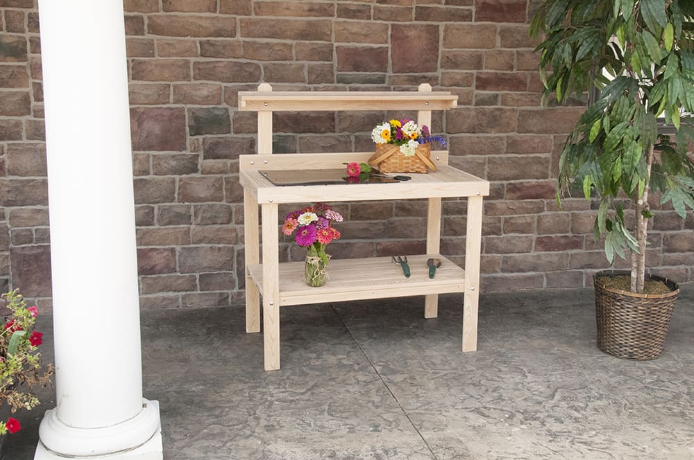 Handcrafted classic garden table made in USA by Amish craftsmen, constructed from unfinished cypress with raised back shelf and lower slatted shelf, ideal for outdoor gardening tasks.