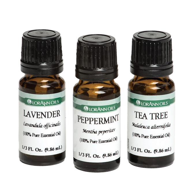 Three amber glass bottles of pure essential oils labeled lavender, peppermint, and tea tree, designed for aromatherapy, health remedies, and crafting uses.