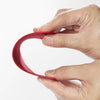 Hand holding a flexible red silicone scraper with a thin metal core, demonstrating its bendable, contoured design ideal for Kitchen & Food, Baking Supplies, and Cooking Helpers collections.