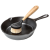 Scrubbing brush with stiff nylon bristles and an ergonomic rubberwood handle resting in a seasoned cast iron skillet, ideal for Kitchen & Food, Cookware, Cast Iron, Best Sellers, and Promo Eligible collections.