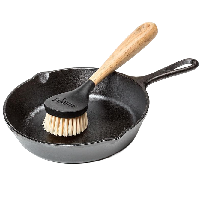 Scrubbing brush with stiff nylon bristles and an ergonomic rubberwood handle resting in a seasoned cast iron skillet, ideal for Kitchen & Food, Cookware, Cast Iron, Best Sellers, and Promo Eligible collections.
