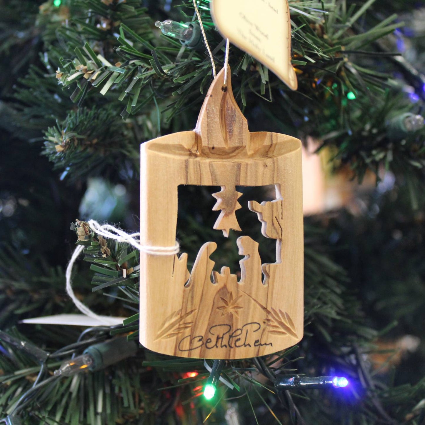 Handcrafted olive wood holiday ornament featuring a carved nativity scene with candle silhouette, perfect for Home & Decor, Holiday Decor, Best Sellers, and Promo Eligible collections.