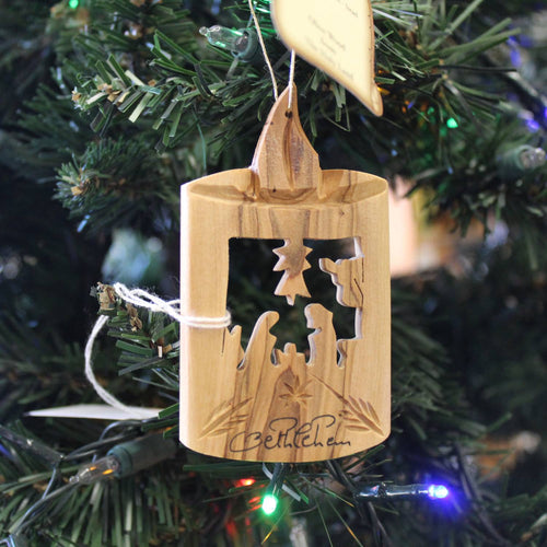 Handcrafted olive wood holiday ornament featuring a carved nativity scene with candle silhouette, perfect for Home & Decor, Holiday Decor, Best Sellers, and Promo Eligible collections.