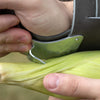 Close-up of a hand using a galvanized steel single hook with leather palm pad and double wrist strap to efficiently remove husks from fresh corn, part of Farm, Garden & Tool, USA Made, Best Sellers, and Promo Eligible collections.