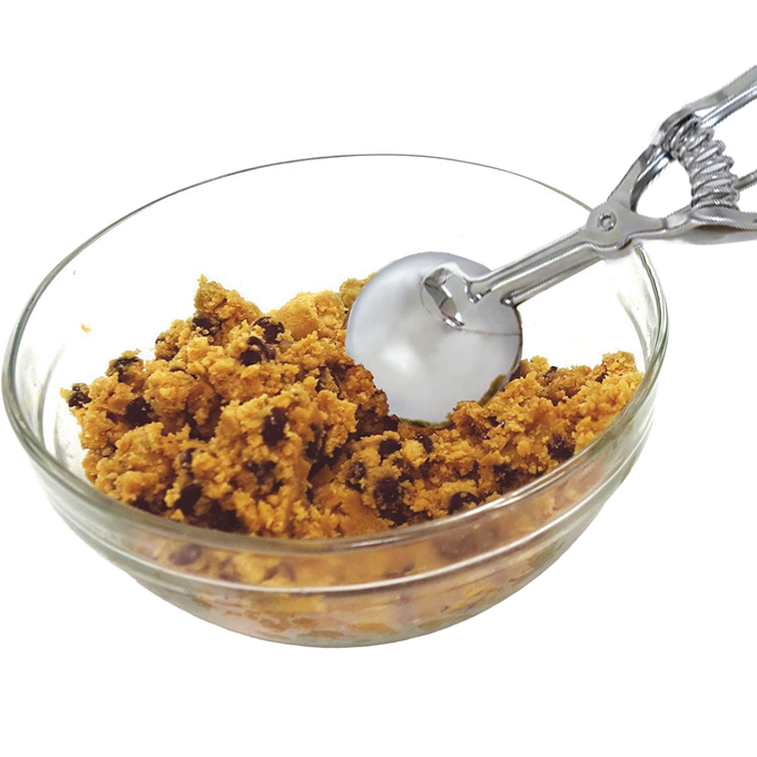 Handcrafted metal scoop with spring release resting in a glass bowl filled with chocolate chip cookie dough, perfect for Kitchen & Food, Cookware, Baking Supplies, Kitchen Gadgets, and Best Sellers collections.