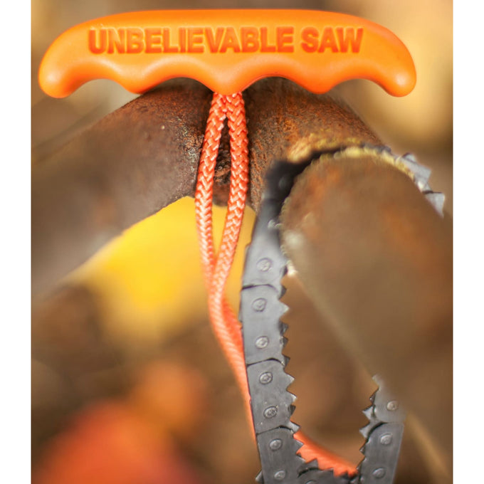 Close-up of a handcrafted pocket chain saw with bright orange handle and sharp teeth cutting through a thick tree limb, made in USA, ideal for Farm, Garden & Tool and Camping collections.