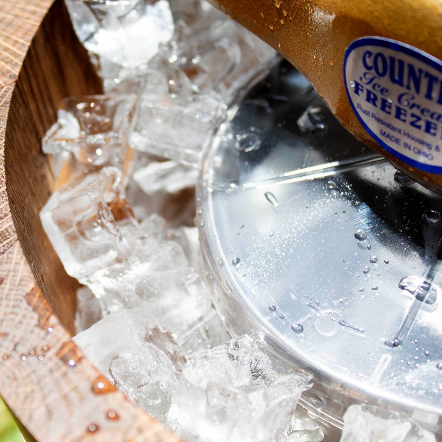 Close-up of a handcrafted Amish made wooden ice cream freezer bucket filled with ice, featuring a metal lid and part of the durable crank handle, ideal for Kitchen & Food and Specialty Equipment collections.
