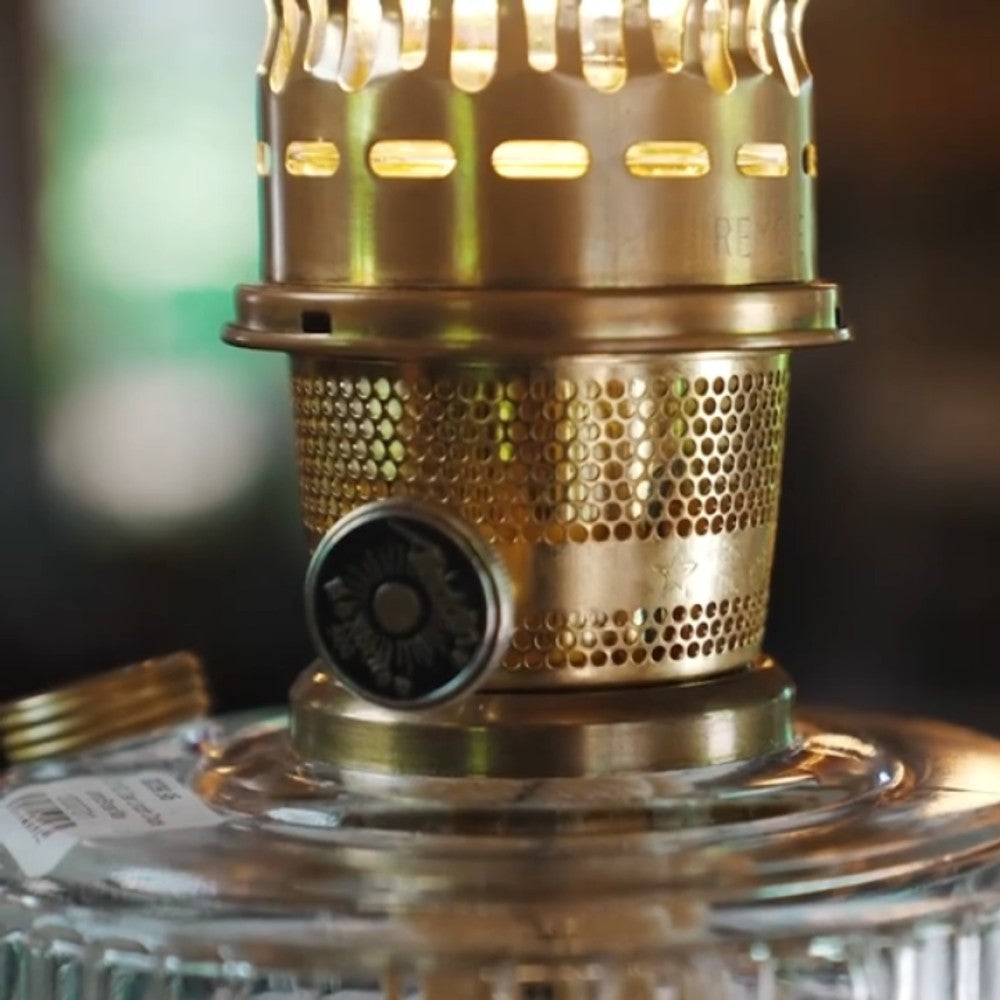 Close-up of the brass burner with a detailed perforated metal wick adjustment knob on a handcrafted amethyst and clear glass oil lamp, ideal for Lamps & Lighting and Best Sellers collections.
