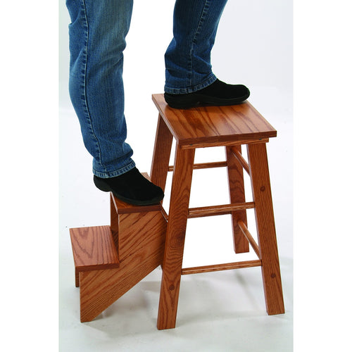 Person wearing black shoes and jeans stepping onto a handcrafted solid oak step stool with smooth lacquered finish, sturdy design, and natural wood grain, ideal for Home & Decor and USA Made collections.
