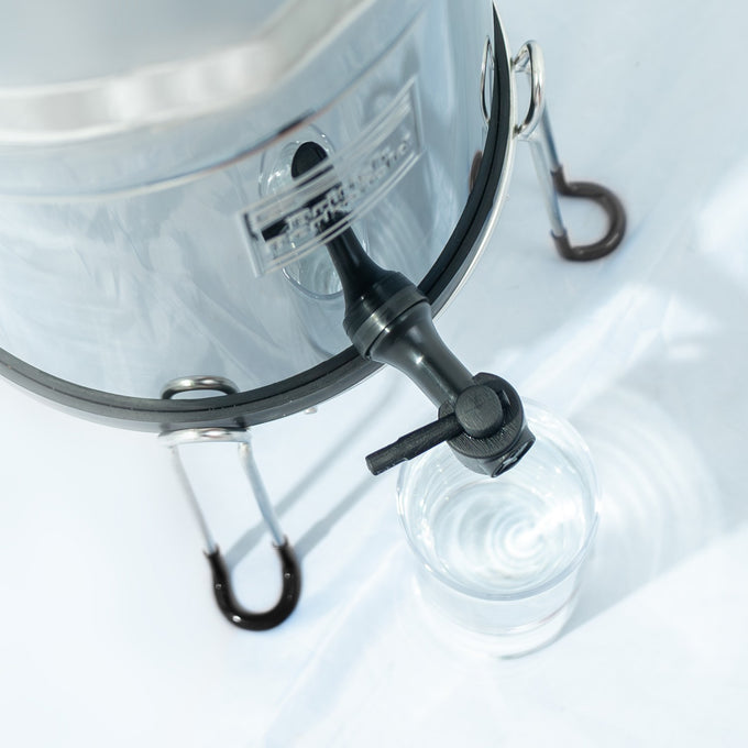 Handcrafted black plastic tap attached to a stainless steel gravity water filter, featured in Appliances, Emergency Supplies, and Water Heating and Treatment collections.