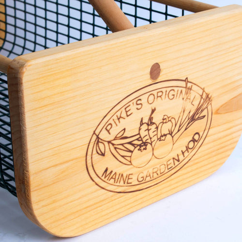 Close-up of engraved wooden end panel on handcrafted Maine Garden Hod featuring vegetables and logo, part of Farm, Garden & Tool, Garden Accessories, USA Made, Best Sellers, and Promo Eligible collections.