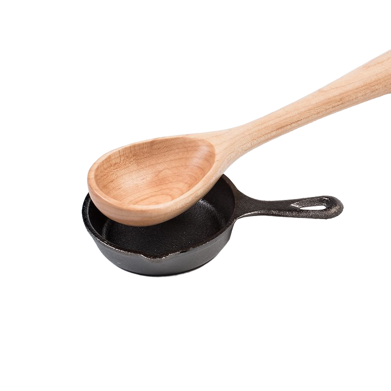Wooden spoon resting inside a small pre-seasoned cast iron skillet, showcasing classic kitchen tools ideal for cookware, cast iron, and kitchen accessories collections.