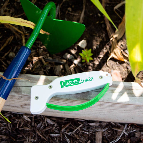 Handheld garden tool sharpener with a white body and green handle, designed to quickly sharpen hoes, pruning shears, and other farm and garden tools, made in USA.