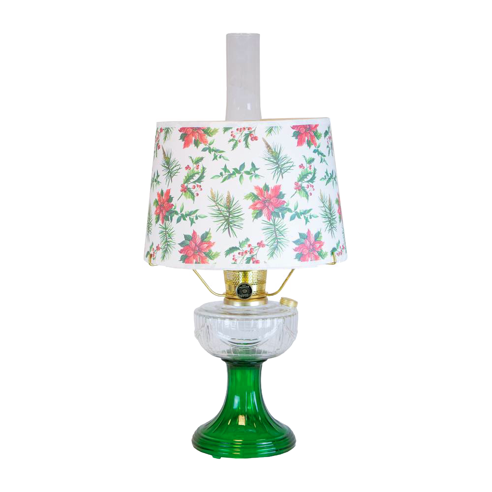 Handcrafted oil table lamp with clear over emerald glass base and festive parchment shade decorated with red poinsettias and green holly, featured in Lamps & Lighting and Best Sellers collections.