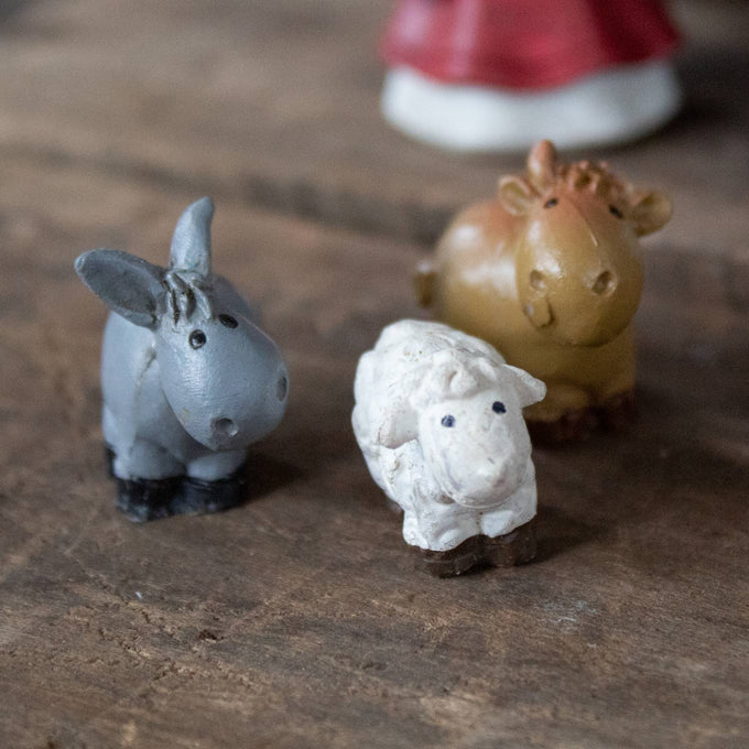 Handcrafted miniature nativity figurines of a gray donkey, white lamb, and brown ox, designed for holiday decor in home and seasonal displays.