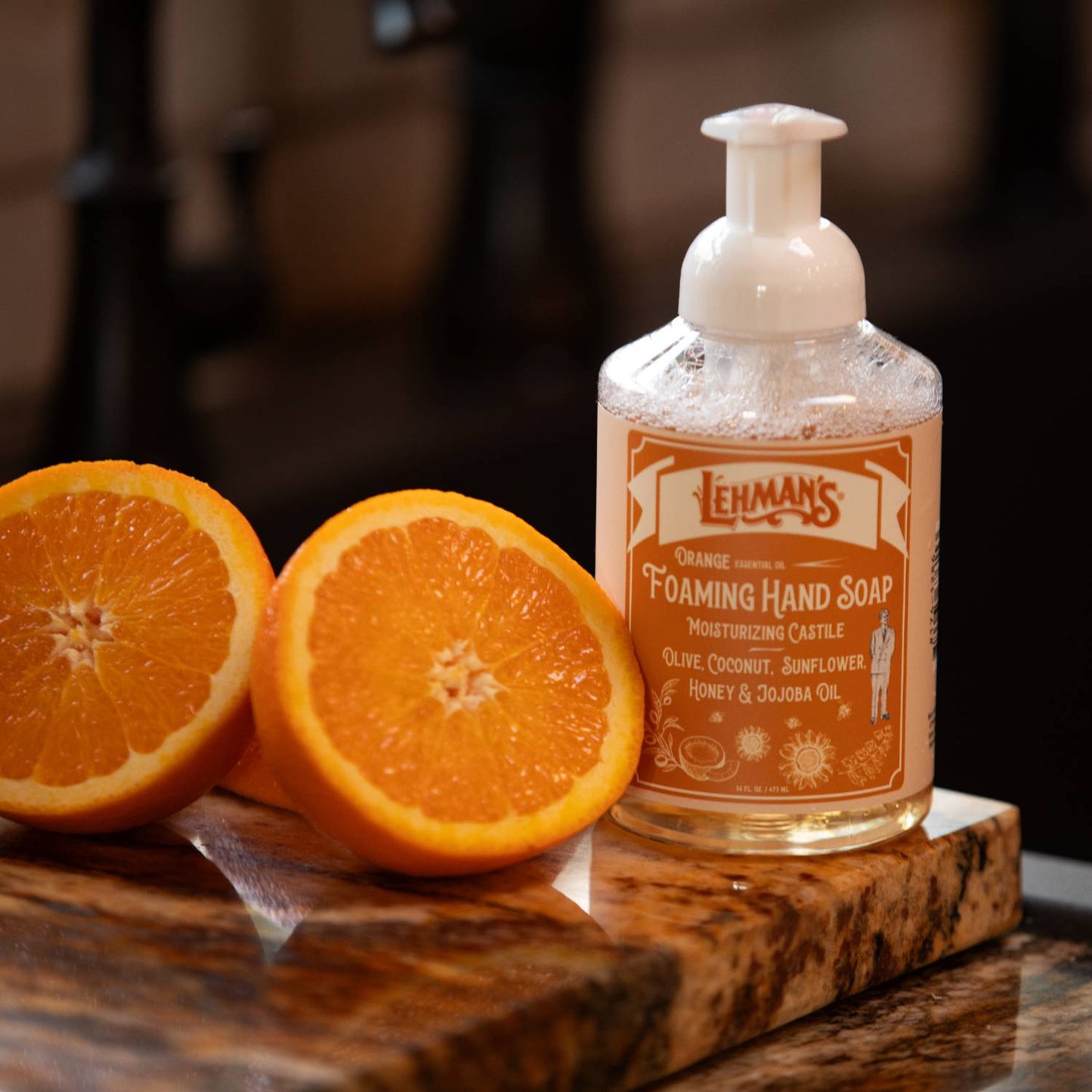 Clear pump bottle of handcrafted foaming hand soap with orange scent, made with olive, coconut, sunflower, honey, and jojoba oils, ideal for Health & Wellness and Grooming collections.
