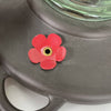 Close-up of a burnt penny plastic base with a red flower-shaped feeding port on a vintage-style clear glass hummingbird feeder, part of Farm, Garden & Tool and Animal Care collections.