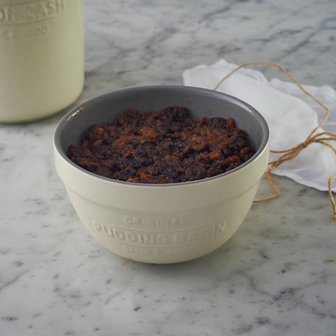 Cream-colored Mason Cash all-purpose bowl filled with a traditional steamed pudding, styled on a marble surface with a rustic twine-tied cloth, ideal for Kitchen & Food, Cookware, Baking Supplies, Storage and Serving, Best Sellers, and Promo Eligible collections.