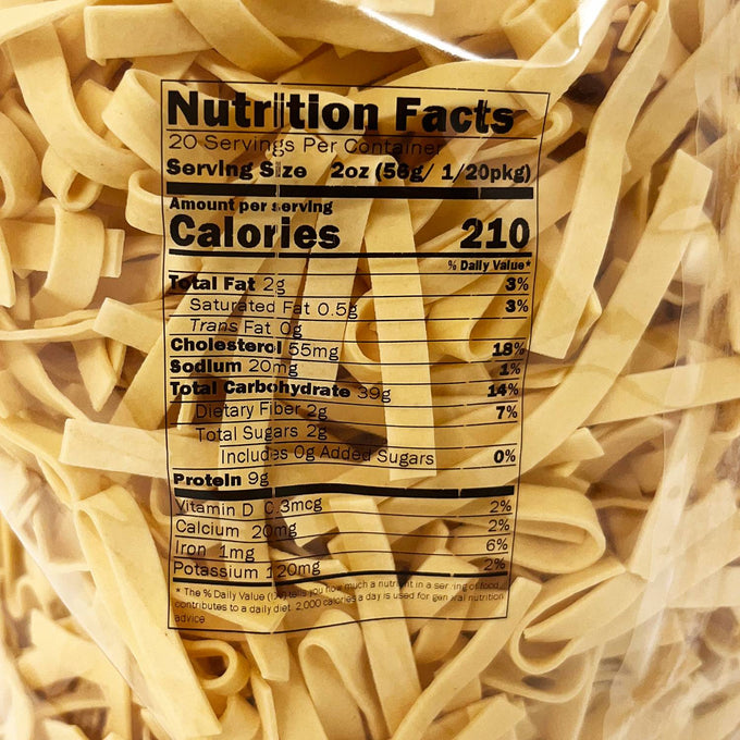 Close-up of a clear bag containing handcrafted wide egg noodles with visible nutritional facts label, ideal for Kitchen & Food, Food, Pantry, USA Made, Best Sellers, and Promo Eligible collections.