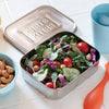 Square stainless steel reusable container filled with fresh mixed salad greens, cherry tomatoes, cucumber slices, and chickpeas, ideal for zero-waste lunch packing in Kitchen & Food and Storage collections.