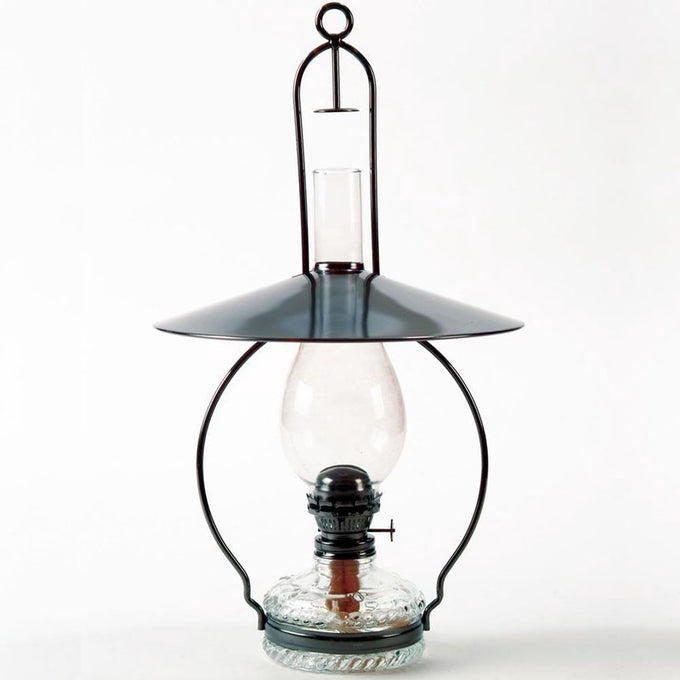 Handcrafted hanging oil lamp with antiqued steel frame, top reflector directing light downward, clear glass chimney, and decorative embossed base, ideal for farm, garden, and homesteading.