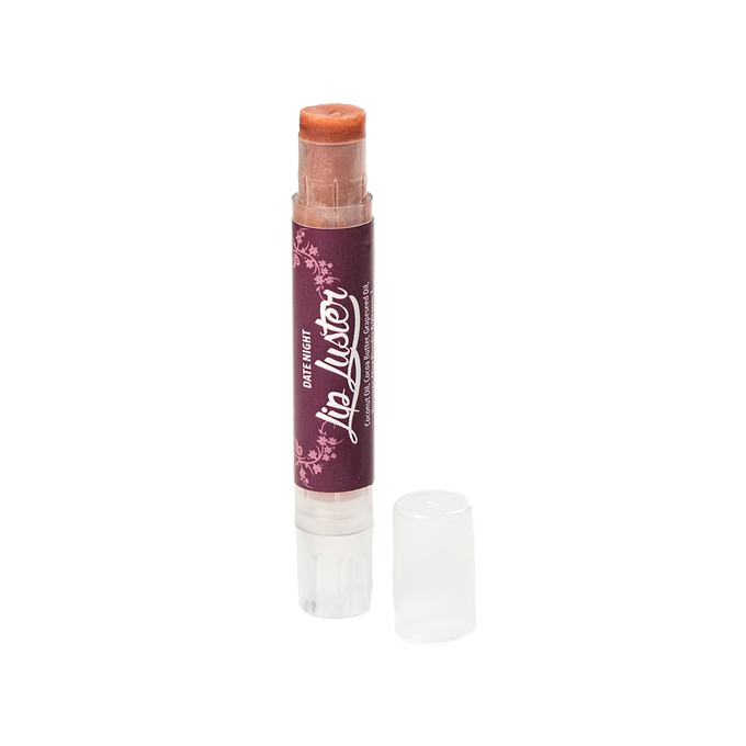 Handcrafted all-natural lip luster in a clear twist-up tube with a dark purple label, part of Health & Wellness and USA Made collections, offering creamy lip care and shine.