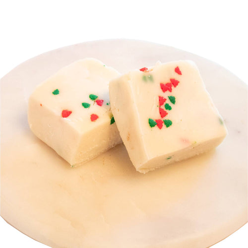 Two handcrafted creamy white fudge squares with festive red and green sprinkles on a smooth white marble plate, featured in Kitchen & Food, Food, Snacks and Sweets, USA Made, Best Sellers, and Promo Eligible collections.