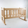 Smooth solid oak doll cradle with slatted sides and gentle rocking base, handcrafted by Amish woodworkers for durable indoor play in children's toys and doll accessories collections.