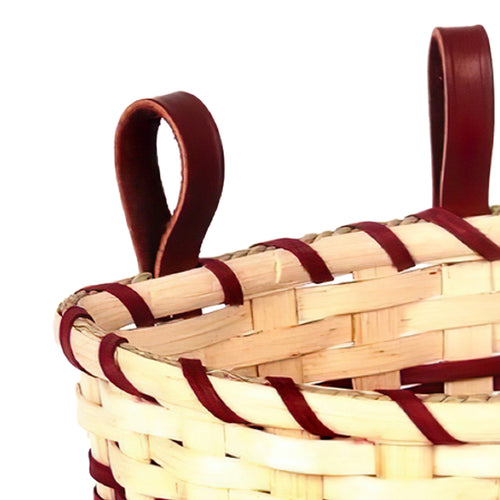 Close-up of woven berry basket with rich leather loops riveted to the rim for attaching to a belt, handcrafted by Amish artisans in the USA, featured in Farm, Garden & Tool and USA Made collections.