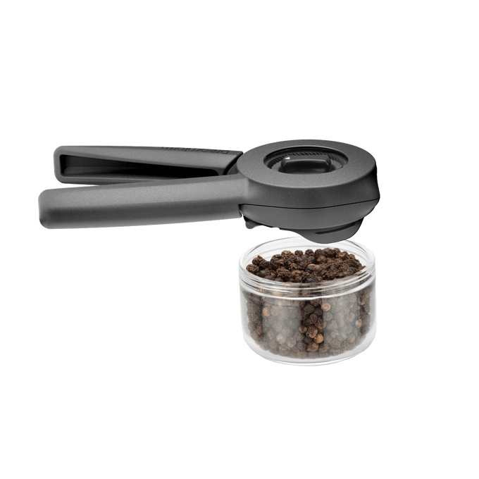 Matte black Ortwo Lite Salt and Pepper Mill with ergonomic dual handles positioned above a clear container filled with whole black peppercorns, designed for Kitchen & Food, Dinnerware, Kitchen Gadgets, Cooking and Baking Helpers, and Storage and Serving collections.