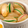 Close-up of handcrafted hard mints with green and red stripes in a white ceramic dish, showcasing a cool peppermint flavor ideal for kitchen, snacks, and USA made collections.