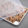 Aluminum half sheet pan with a clear plastic lid, showcasing freshly baked dessert bars topped with chocolate chips and butterscotch, ideal for Kitchen & Food and Baking Supplies collections.
