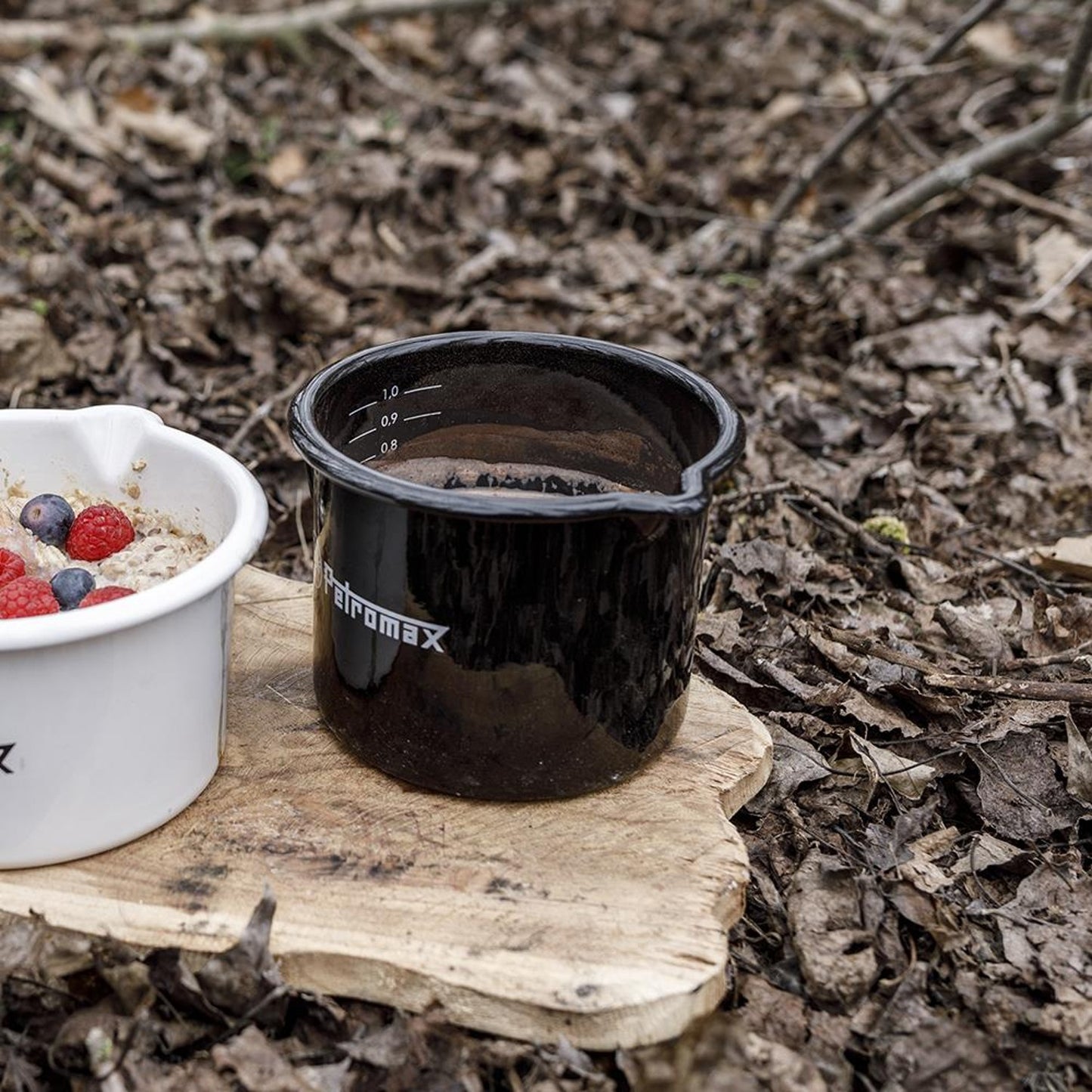 Black enameled steel milk pot with pour spout and white volume markings, handmade for durable use in outdoor kitchens, camping, farm, garden, cookware, and best sellers collections.