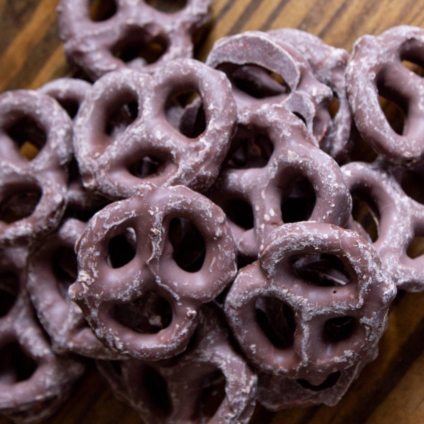 Close-up view of handcrafted mini pretzels coated in creamy milk chocolate, a USA made snack perfect for Kitchen & Food, Snacks and Sweets, Candy, Best Sellers, and Promo Eligible collections.
