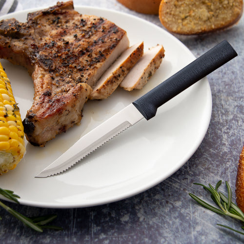 Handcrafted serrated steak knife with high carbon surgical quality stainless steel blade and solid black handle, made in USA, ideal for Kitchen & Food and Farm, Garden & Tool collections.