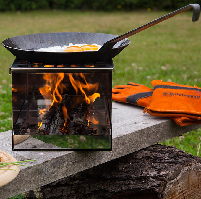 Cast iron pan with a long handle cooking two sunny-side-up eggs over an open flame on a portable outdoor stove, perfect for Farm, Garden & Tool, Kitchen & Food, Camping, Cookware, Pots and Pans, Best Sellers, and Promo Eligible collections.